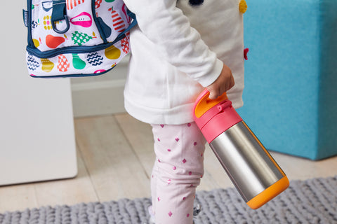 a child with a backpack holds an insulated stainless steel water bottle