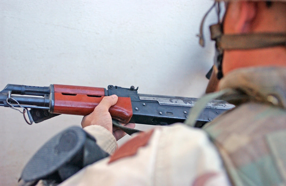 A soldier from Task Force Dragoon examines an AK-47 discovered during a raid on a home as part of Operation Hurtgen Forest on June 6 in Bayji, Iraq