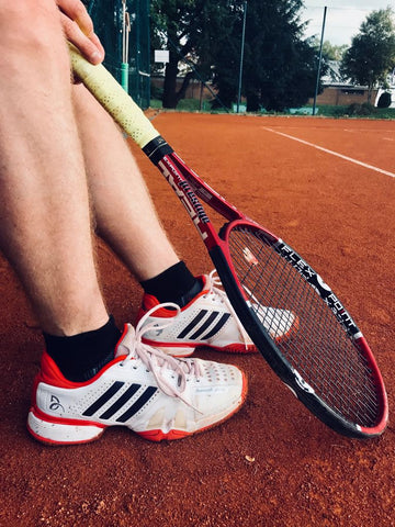 Foto von Tennisschuhen mit WRIGHTSOCK auf dem Tennisplatz