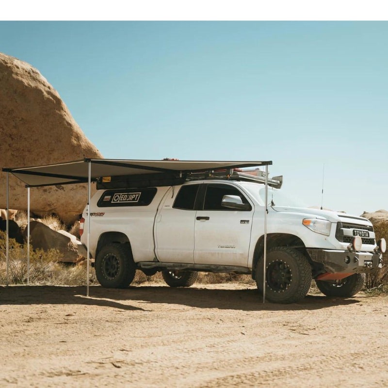 eezi-awn-dragonfly-180-open-beige-top-corner-view-on-toyota-tundra-in-terrain