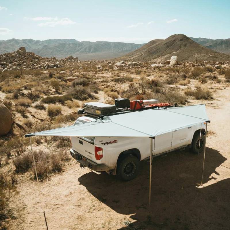 eezi-awn-dragonfly-180-open-beige-top-corner-view-on-toyota-tundra-in-terrain