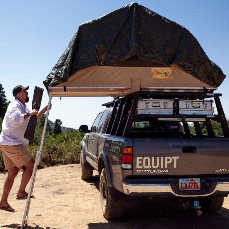 eezi-awn-jazz-soft-shell-roof-top-tent-open-rear-view-on-vehicle-with-person-on-ladder-in-nature