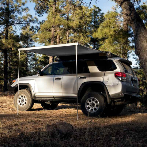 eezi-awn-lite-awning-gray-open-side-view-on-toyota-4runner-in-forest-clearing