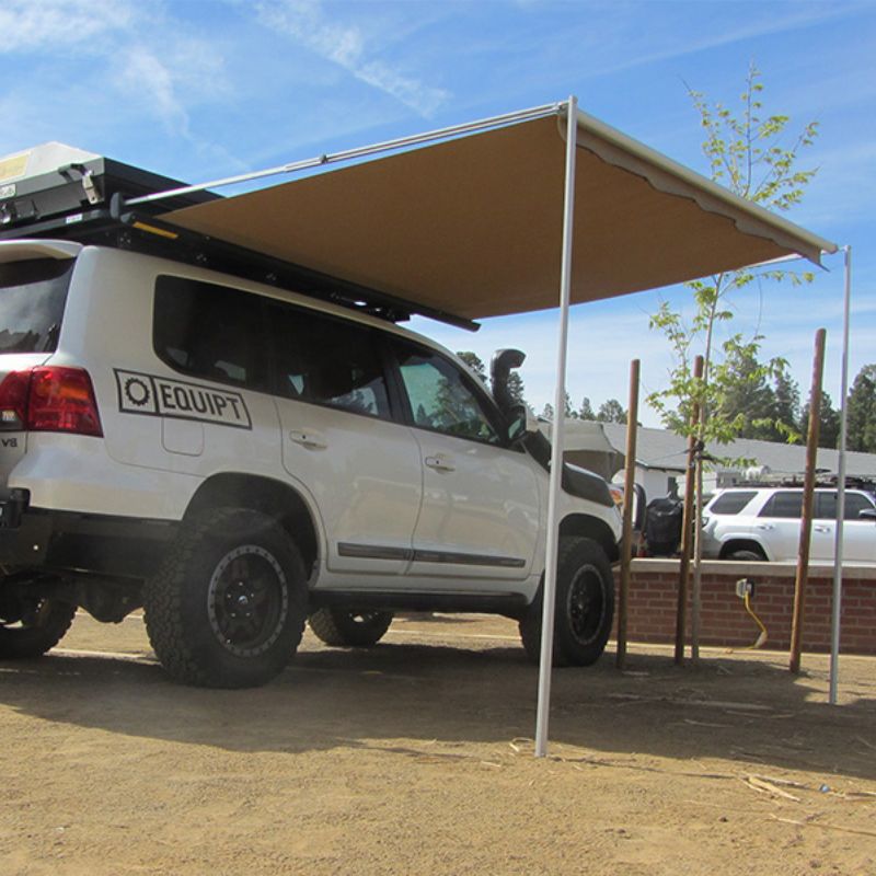 eezi-awn-series-2000-awning-beige-open-rear-corner-view-in-black-hard-case-on-land-cruiser-in-parking-area