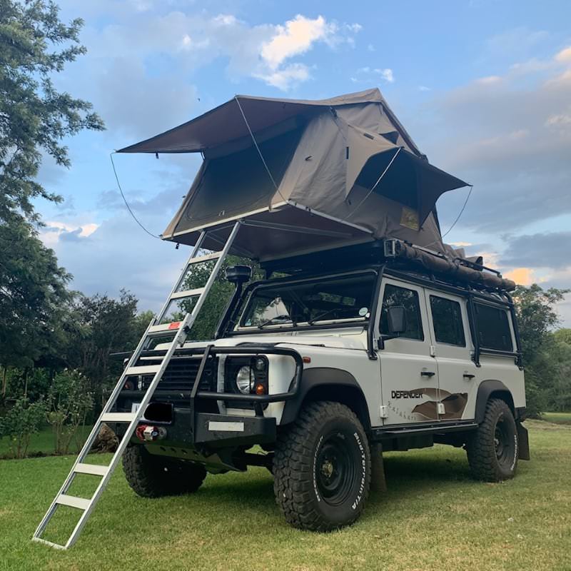 eezi-awn-series-3-roof-top-tent-beige-open-front-corner-view-on-land-rover-defender-on-lawn