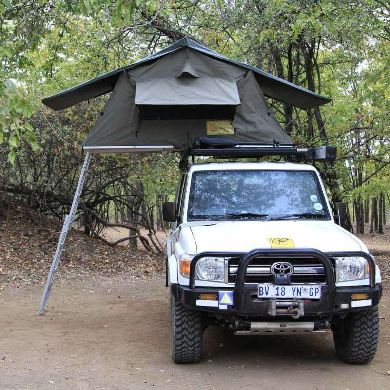 eezi-awn-series-3-roof-top-tent-olive-open-front-view-on-vehicle-with-extended-ladder-in-forest