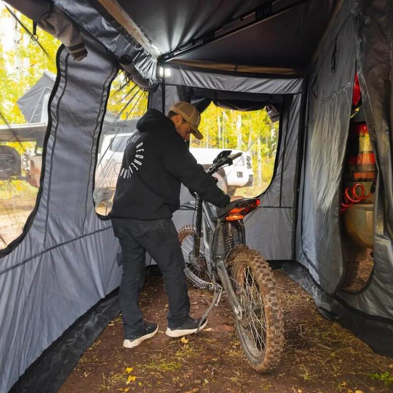 freespirit-recreation-270-awning-room-driver-side-open-interior-view-with-person-and-dirtbike