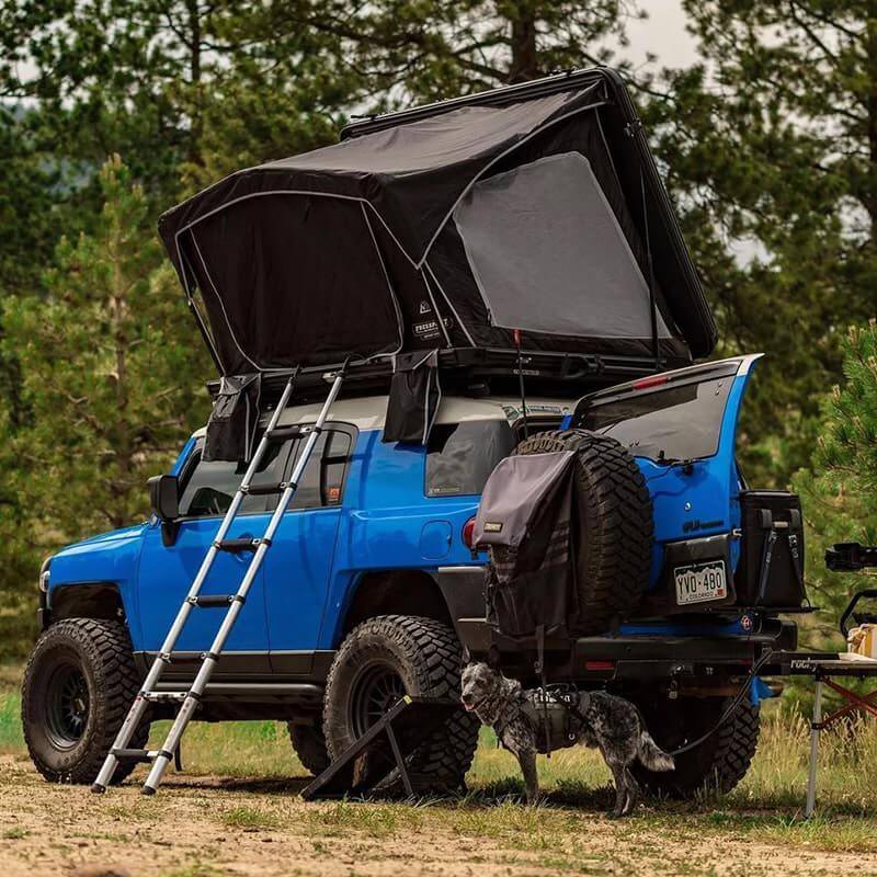 freespirit-recreation-odyssey-black-hard-shell-roof-top-tent-open-rear-corner-view-on-toyota-fj-with-mesh-window-in-nature