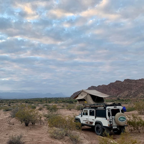 open-road-overland-land-rover-defender-with-eezi-awn-series3-soft-shell-roof-top-tent-open-rear-corner-view-in-nature