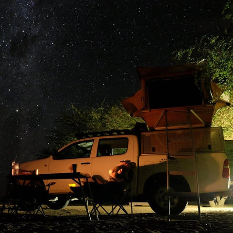 open-road-overland-toyota-hilux-with-eezi-awn-series3-soft-shell-roof-top-tent-open-side-view-in-nature-with-person-enjoying-the-night-sky