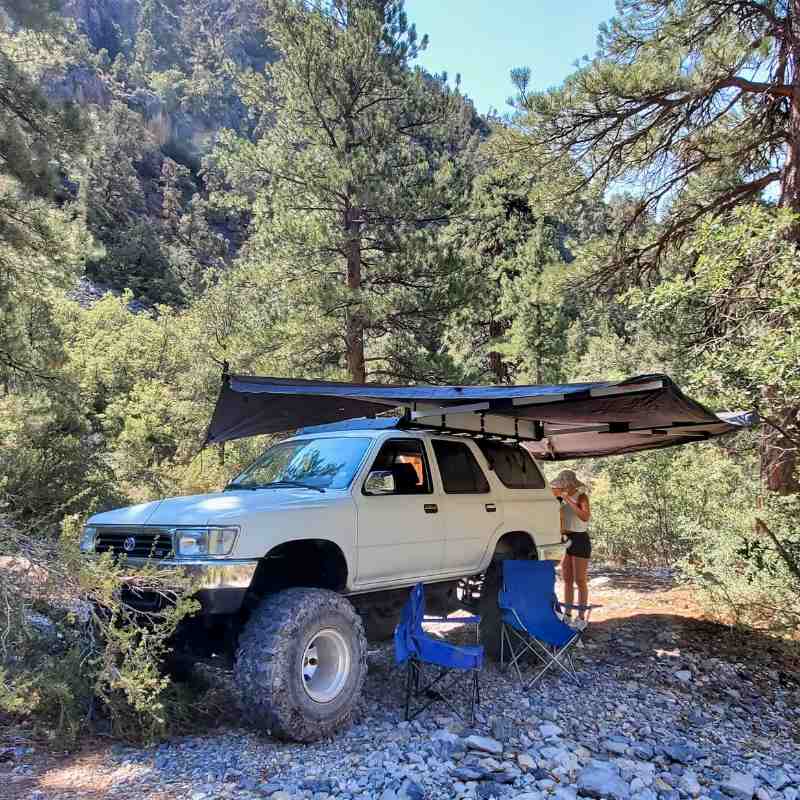 overland-vehicle-systems-awning-270-front-view-on-toyota-with-person-in-nature