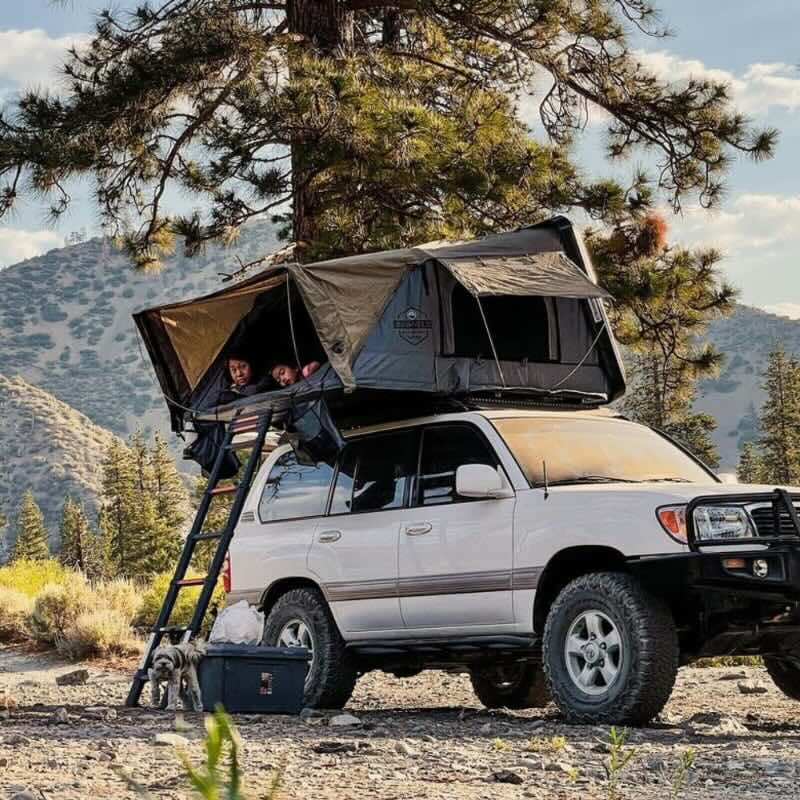 overland-vehicle-systems-bushveld-hard-shell-roof-top-tent-open-front-corner-view-on-toyota-land-cruiser-with-people-inside