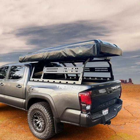 overland-vehicle-systems-discovery-rack-rear-corner-view-on-toyota-tacoma-with-roof-top-tent-and-driver-side-awning-in-desert