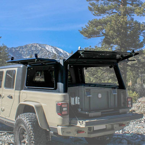 overland-vehicle-systems-expedition-truck-cap-for-jeep-gladiator-rear-corner-view-opened-cap-doors-in-the-mountains