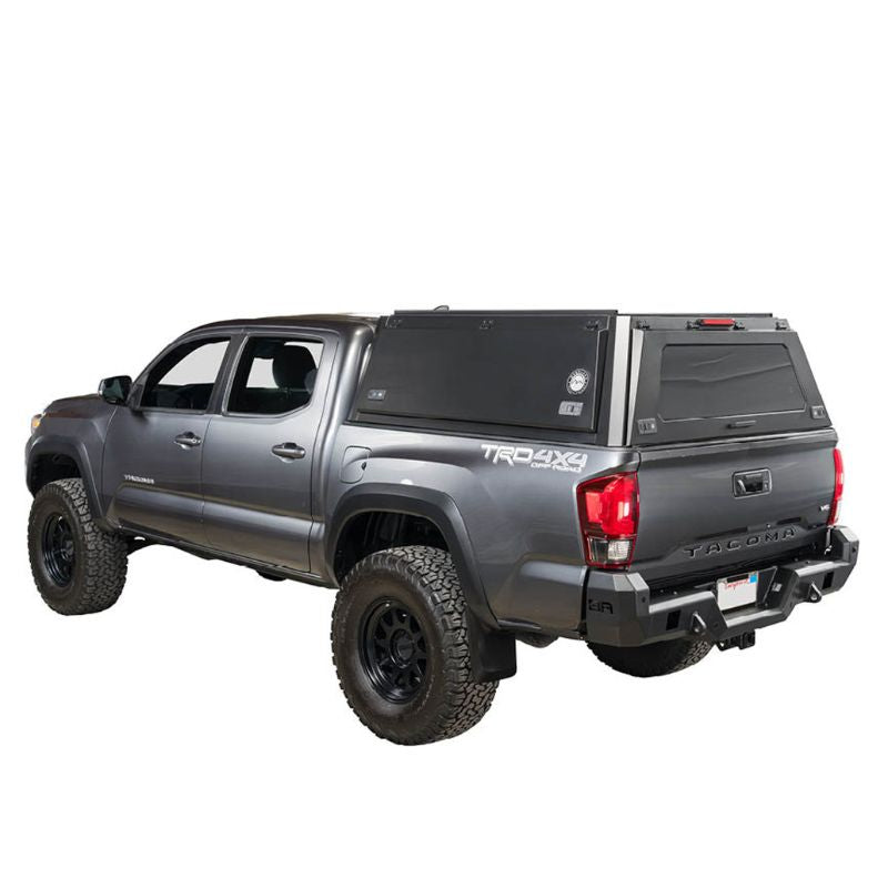 overland-vehicle-systems-expedition-truck-cap-for-toyota-tacoma-black-open-rear-corner-view-on-toyota-tacoma-on-neutral-background