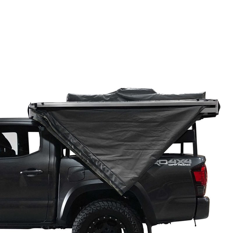overland-vehicle-systems-nomadic-awning-180-driver-side-partly-opened-side-view-on-toyota-tacoma-on-white-background