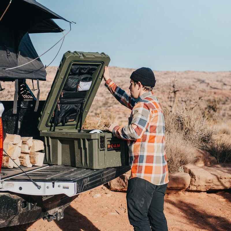 roam-105l-lid-organizer-front-corner-view-in-rugged-case-with-person-in-terrain"