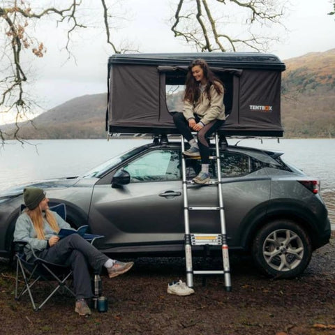 tentbox-classic-hard-shell-roof-top-tent-open-side-view-on-nissan-juke-at-lake-side-with-persons-camping