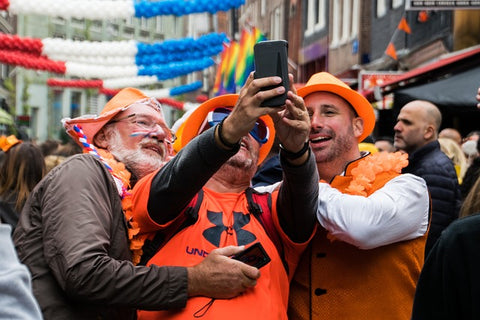 3 men in King's Day clothes taking a selfie