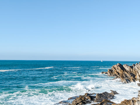 Western coast of Europe, Baleal Peniche Portugal, Horizon with waves crashing on stones on the coast.