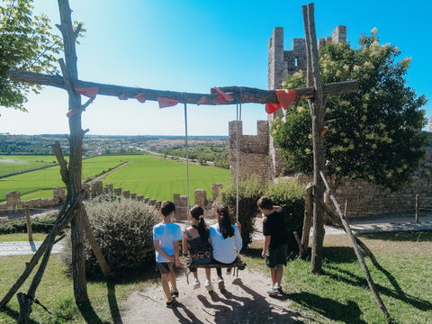 Kids sitting on a swing, baloiço, at the Castle of Montemor-o-Velho in Portugal overlooking the lush countryside.