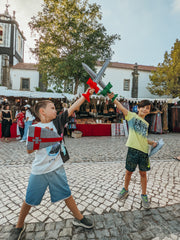 Two young boys playing with felt swords at the Castle of Obidos in Portugal
