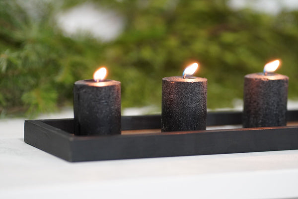 3 crne rusticne svece na stolu