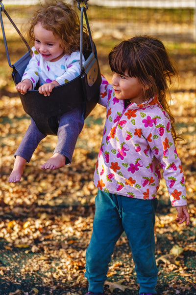 two children having fun and playing on the swings