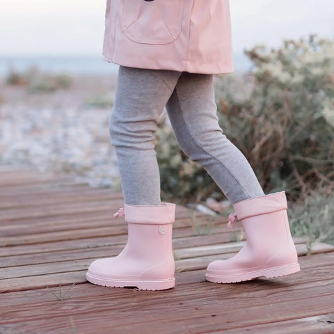 fille avec bottes de pluie roses qui marche