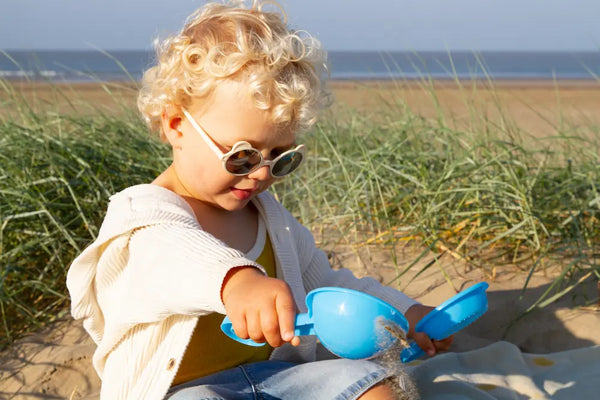 bébé avec lunettes a la plage