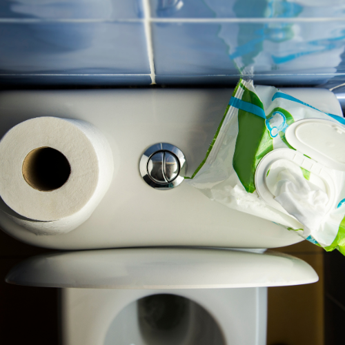 toilet paper and baby wipes on top of toilet tank