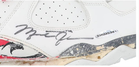 Close-up view of a pair of 1992-93 game-used, twice-signed Air Jordan 8 sneakers from Michael Jordan. The shoes are visibly worn, with signs of age and use, notably the degraded soles. The main highlight is Jordan's signature on each shoe's outstep, written in bold black marker