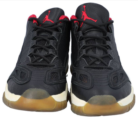 A detailed shot of the 1996 game-used, signed Nike Air Jordan XI sneakers, showcasing their iconic design and the light wear indicative of their use on the basketball court