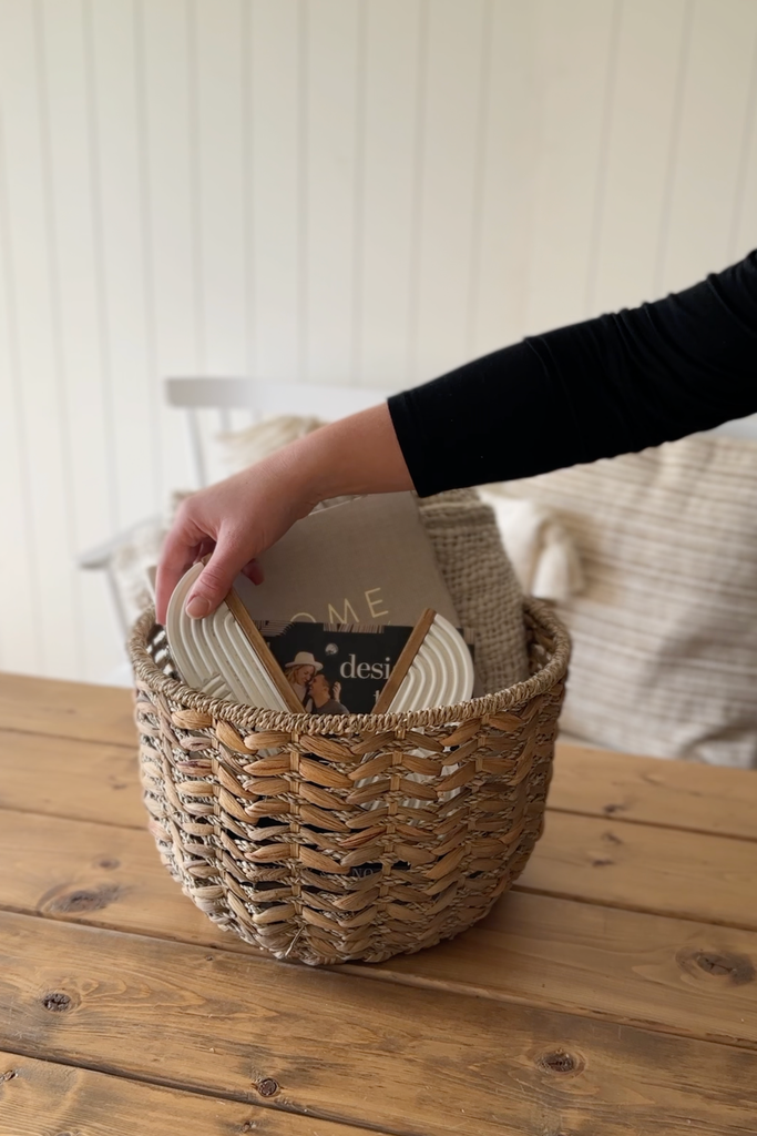 Hand placing bookends into home decor gift basket