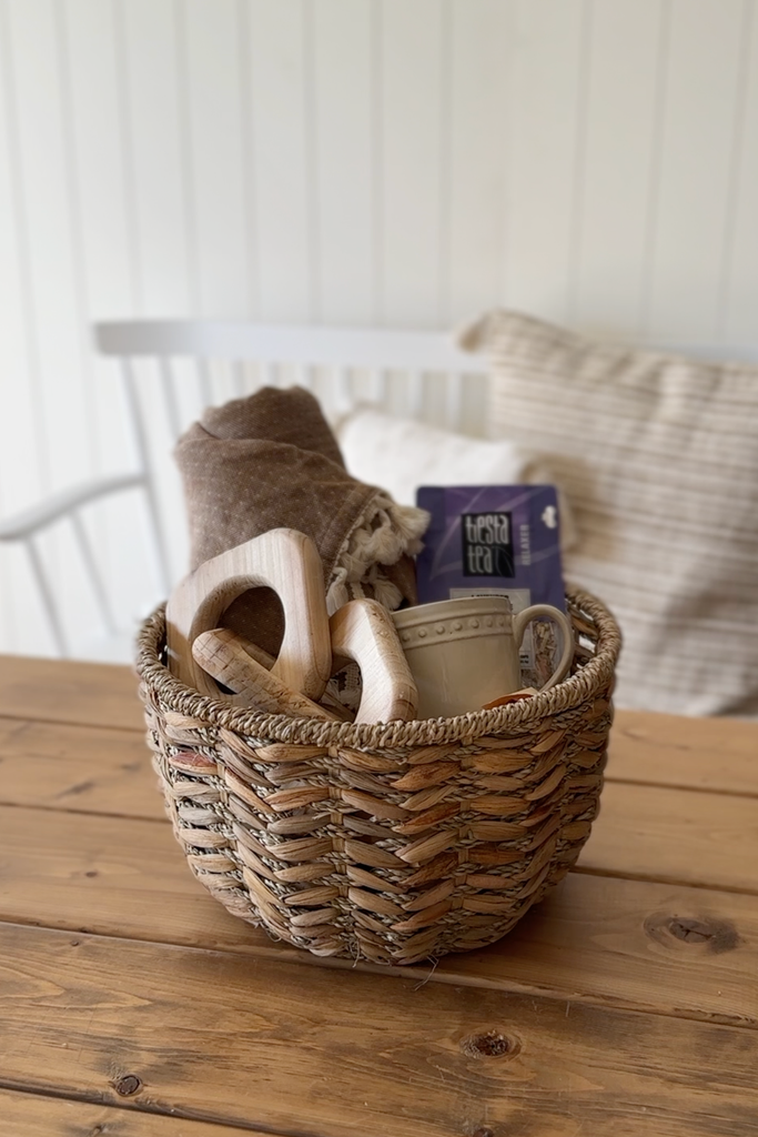 Completed cozy gift basket with throw, mug, tea leaves and decorative chain