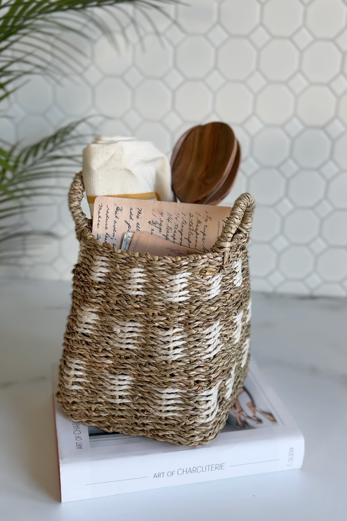 gift basket with towel, serving utensils and recipe cards in a marble kitchen