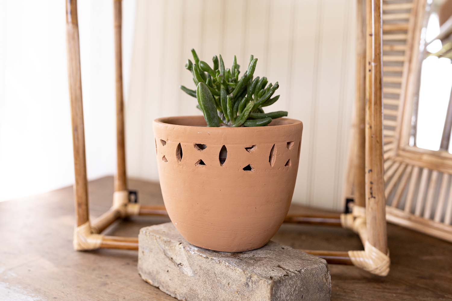 terracotta planter on brick and cane shelf