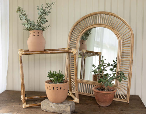 patio setting with cane rattan mirror, shelf and terracotta planters and vase