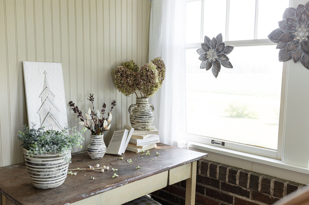 cottage style porch with vases, planters and wall art