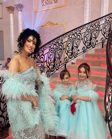 Vjosa Muriqi and her daughters radiate charm in Blini's aqua dress ensemble.