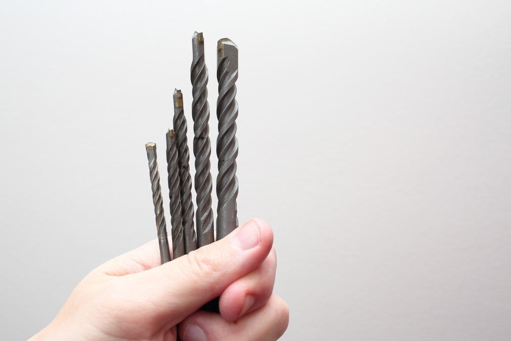 Hand holding five different drill bits