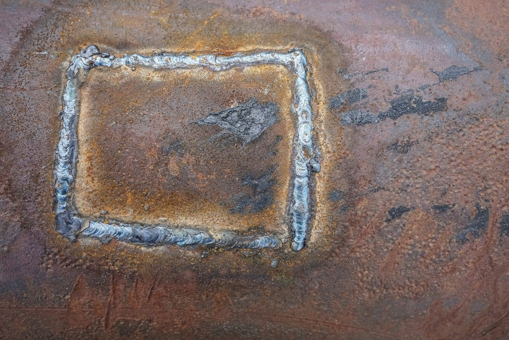 Rusted square weld on metal pipe