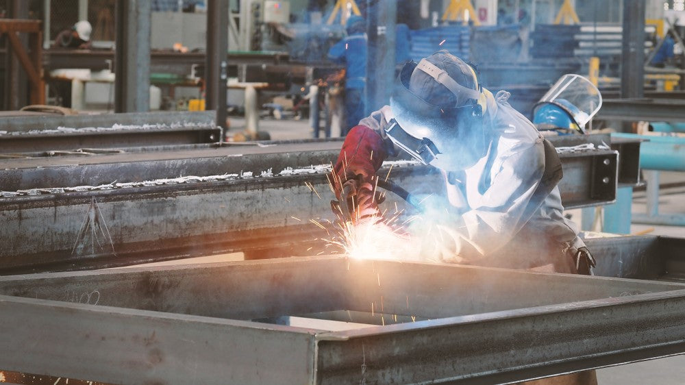 Welding working in industrial setting