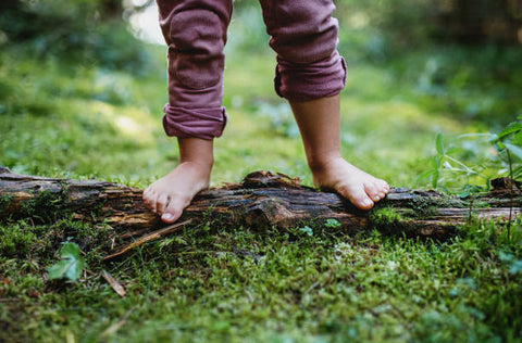 Child's feet barefoot in forest