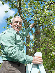 man places bird feeder in best location