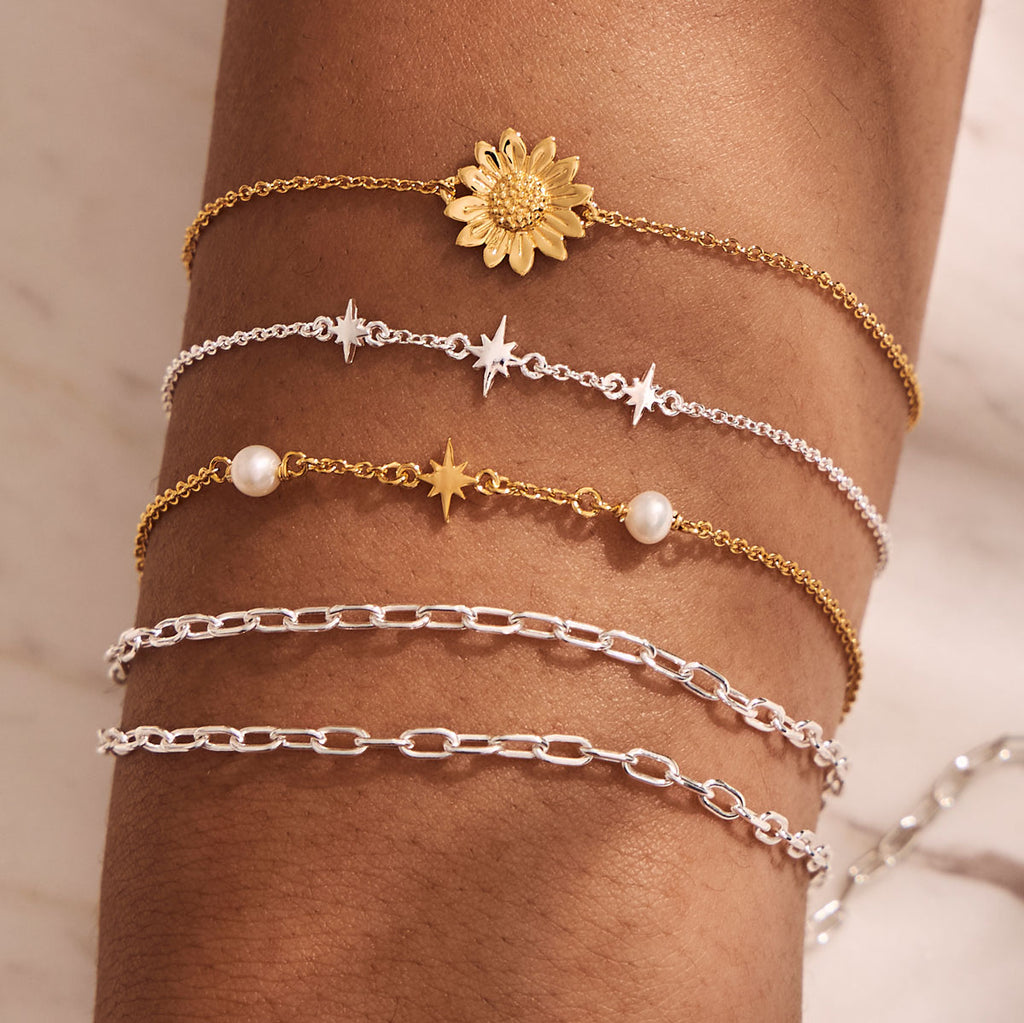 silver and gold bracelets layered on wrist