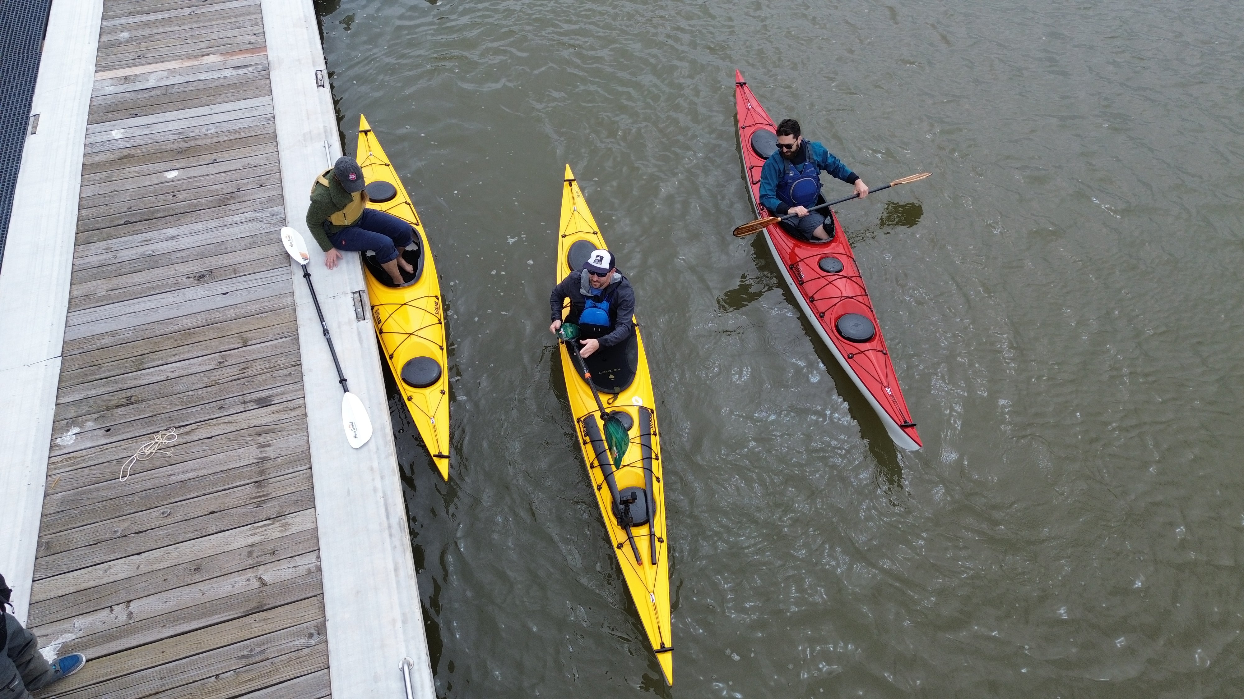 three people in kayaks