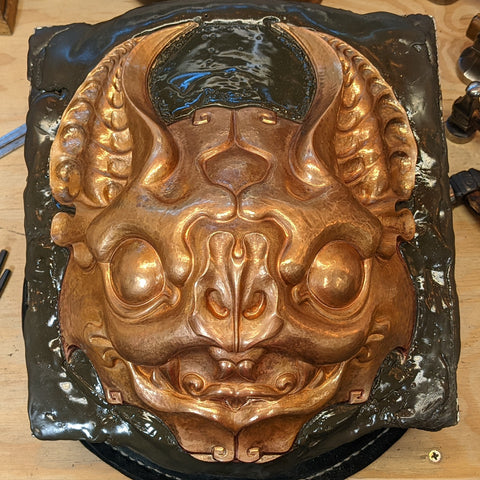 A mask made from raised copper in the form of a stylized bat