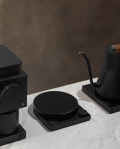 A black Fellow Ode, Tally, and EKG kettle lined up on a marble counter.
