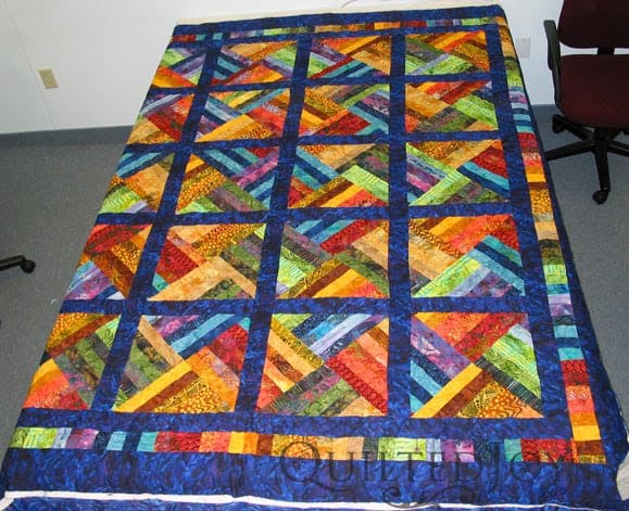 Luscious Batik Strip Quilt with Pretty Posie Panto, edge to edge quilting by Angela Huffman - QuiltedJoy.com